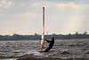 701003_ Windsurfer an Windsegel tief in Wasser stehend gegen den Wind auf See herausfahren seitlich am “Rigg”