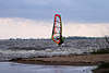 701048_ Windsurfer auf Brett mit Segel im Wasser auf Wellen der Elbe in Ufernähe beim stürmischen Wetter
