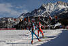 815922_ Biathleten Paar auf Skiloipe im Biathlonstadion unter Steinbergen Foto im Lauf an Zuschauer