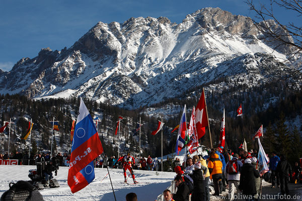 Biathleten Loipe mit Zuschauer Fahnen in Hochfilzen Biathlonstadion unter Berg in Schnee