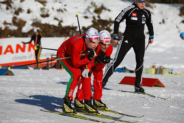 Biathleten-Paar eng Skifahren Damen zusammen beianander im Rotkleid