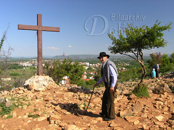 Medjugorie Pilger in steinigen Landschaft vor Kreuz am Marienerscheinungsort