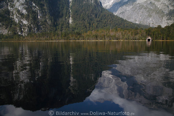 Knigssee felsiger Naturufer Foto mit Holzhtte am Wasserufer unter Bergwand