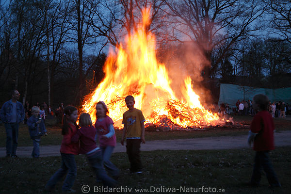 Kinderspass Foto bei Osterfeuer Dmmerung Osternzeit Bild traditionelles Feiern auf Dorfplatz