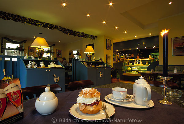 Caf-Blick ber Windbeutel Kaffeegedeck auf Tisch in Kerzenlicht Bedienung hinter Theke