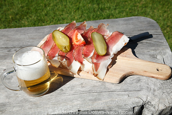 Speckbrot mit Bier Krug Brett-Jause Speckstreifen garniert mit Gurken