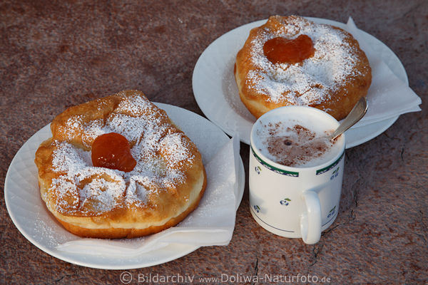 Selbstgebackene Krapfen-Duo auf Steinplatte in Abendlicht am Kakaobecher
