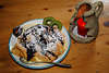 Palatschinke Dessertteller mit Schokoladensoße, Vanillensoße Foto auf Holztischbrett bei Kerze