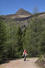 12001764_Rucksacktouristin auf Bergweg Foto unter Gipfel Knoten Alpenlandschaft grne Bume Natur Wanderausflug Bild