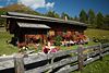 003521_Wanderrast auf Gotschaunalm Frau sonnen vor blumigen Almh�tte Bild in Osttirols Berglandschaft