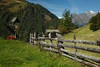 Almwiese Holzzaun Wanderin unterm Marterl Kreuz in Alpenlandschaft Virgental Naturfoto