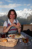 Adler Lounge Frau vor Speisen in Wolkenhöhe mit Panoramablick auf Alpengipfel
