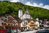 105711_Hallstatt Markt Hotels & Wohnhäuser Foto unter kath. Pfarrkirche am grünen Berghang in Frühling