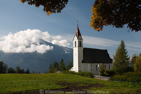 Kirchlein von Msern Herbstfoto Dorfwiese vor Berg in Wolken