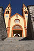 Zweiturmkirche Telfs Treppe Eingangstor gelbbraun Fassade am Himme