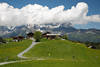 Erbalpe Frhling Naturfoto Bauernhof Grnwiesen vor Bergpanorama Kaisergebirge in Wolken