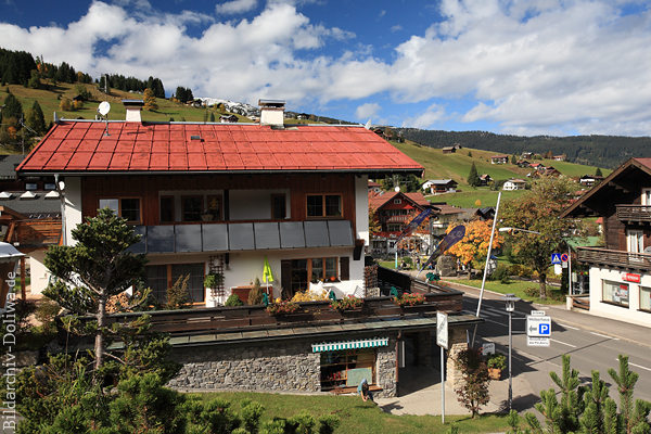 Hirschegg Dorfzentrum Foto Kleinwalsertal Alpenort Berghang Häuser Strassenbild
