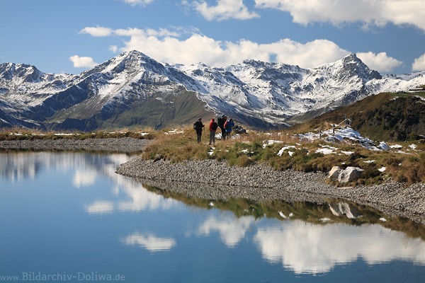 Alpensee Wasserufer Wandertrupp in Naturbild Zillertaler Hochgebirge Gipfelpanorama mit Schnee