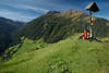 Bergalm Grünwiesen Wanderin Rast unterm Marterl Kreuz mit Gipfelblick Virgental Alpenlandschaft Naturfoto