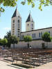 Bd0037_ Medjugorie Gotteshaus, Doppelturmkirche Foto ber Bnkenreihe auf Kirchplatz