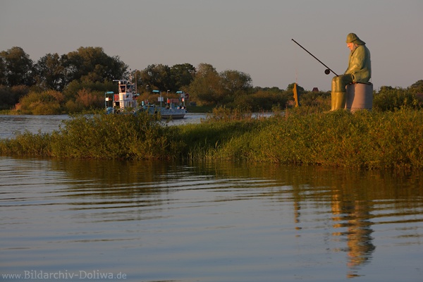 Elbfischer Angler-Statue vor Flussfähre Bleckede Wasserufer Denkmal in Abendlicht