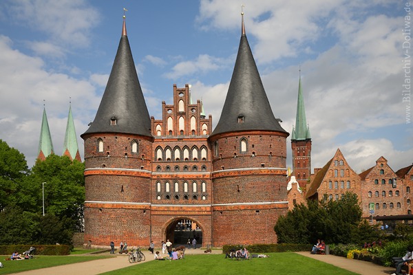 Holstentor Lbeck Altstadt historische Trme Backsteinbau ber Grnwiese Besucher