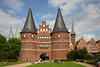 Holstentor Lübeck Alstadt historische Türme Backsteinbau über Grünwiese Besucher