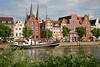 Altstadt L�beck am Wasser Untertrave Uferpflanzen Naturfoto mit Segelschiff vor H�usern