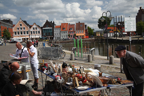 Husumer Hafenflohmarkt Bild Kaufinteressent am Stand schaut sich Trdelsachen in Foto an