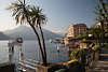 907490_Bellagio Hafenbild in Sonne unter Palmen am Comer See mit Alpenblick, Hotel & Café am Wasser