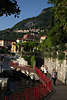 907552_ Varenna Fusssteg Foto Pfad mit Touristen entlang Lago di Como hoher Felsenküste vor Varenna Häuser