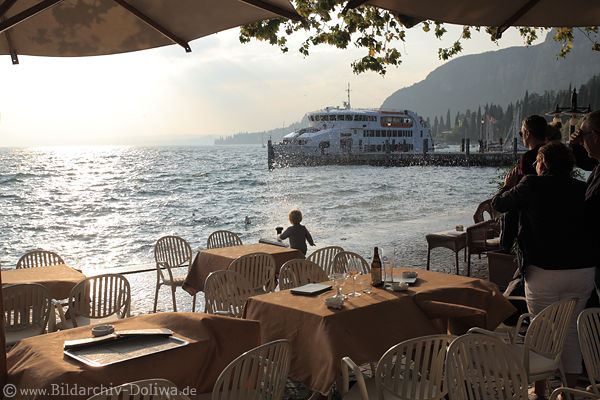 Garda Uferkante Kind in Spritzwasser Tische vor Wellen