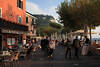 Garda Flaniermaile Foto Bars Cafés Urlauber im Freien Südsonne Gardasee Wasser-Bergblick