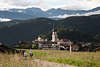 1100934_ Wandererpaar auf Fusspfad vor Kastelruth Stadthäuser in Südtirol weiten Landschaft Panorama