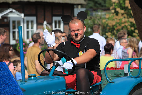 Lustiger Treckerfahrer in Verkleidung bei Erntedankfest Parade durch Heidedorf Steinbeck lcheln