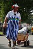 Komödiant lustige Verkleidung Foto: Mann in blau Streifenhose zieht Kleinwagen in Sandalen beim Steinbecker Erntefestumzug