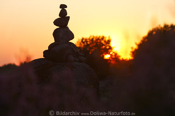 Troll Silhouette am Himmel Glcksbringer Steinpyramide vor Sonnenuntergang in Heidelandschaft
