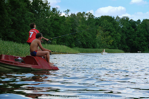 Junge Angler im Trettboot angeln in Wasser Seenlandschaft Masuren Fische fangen Fliegenfischen