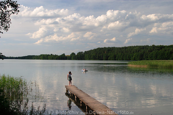 Mdchen auf Seesteg in Wasser Seenlandschaft Masuren Abschied nehmen Trennung Trauer Kind einsam vor Wolken Natur Stille Spiegelung Schlauchboot