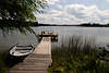 Martinshagener See in Masuren Wasserlandschaft Melancholie Bild, Boot am Holzsteg in Schilf