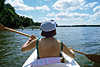 Frau im Kajak-Boot Masuren Sonne entgegen paddeln in Wasser Buwelno-See