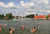 Nikolaiken Jugendliche Strandball in Wasser Badespass in Masuren Stadtpanorama Brücke Sicht