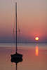 Rote Sonne über Seehorizont Romantik Sonnenuntergang Bild mit Segelboot in Wasser Spirdingsee