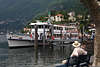 906126_ Ascona Paar auf Bank unter Baum an Seepromenade Bild, Lago Maggiore Schiff an Anlegestelle