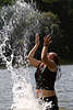56908_Wasserspiele Bild in Wasserspritzer Mädchen Bad in Süsswasser See lässt Wasser nach oben werfen