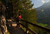 913577_Bergwanderer Portrt auf Naturpfad Frau unter Bumen in Sonne Lichtstimmung am Gelnder