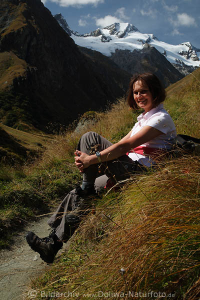 Mdchen Wanderin vor Gletscherschnee auf Bergwiese lcheln in Gras Naturfoto
