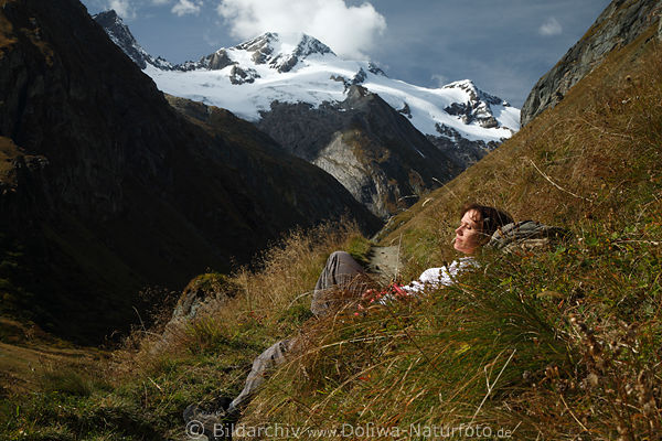 Mdchen in Bergpfad-Grser liegen vor Gletschersicht Naturportrt in Alpenkulisse