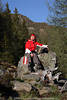 1202067_Fröhliches Mädchen Porträts auf Steinsitz lachende Bergwanderer Relax in Natursonne Fotos junge Frau mit Rucksack