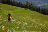 1202179_Frau Naturporträt auf Blumenwiese in weiß-gelb Blütenfeld Foto am Berghang Grüngras sitzen